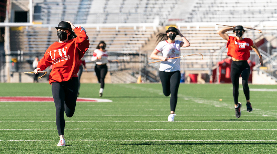 students running on the field of Camp Randall for cane toss 2021